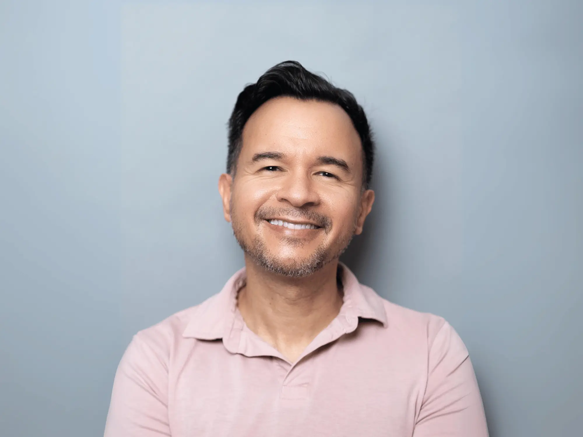 Dr. Israel Martinez smiling in a pink polo shirt